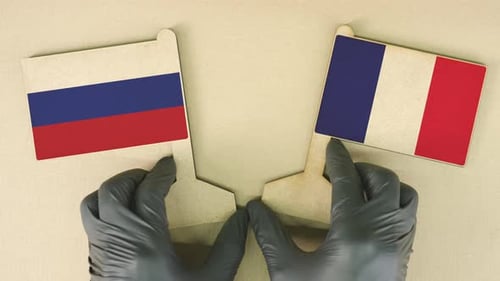 Russian and French Flags Placed on a Tan Surface