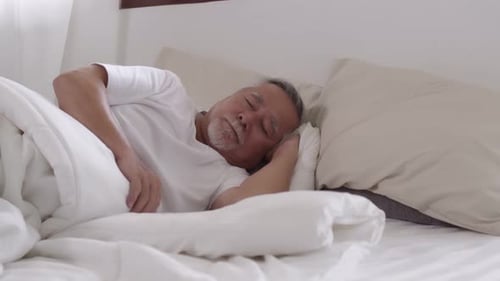 Peaceful Senior Man Sleeping Comfortably in Bed