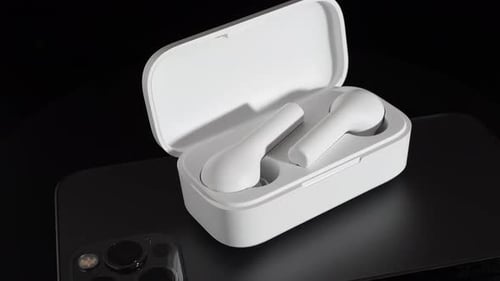 White Wireless Earbuds with Charging Case on Phone
