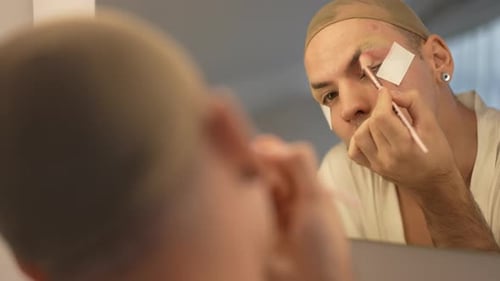 Young Adult Applying Makeup in Front of Mirror