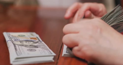 Hands Sorting Stacks of One Hundred Dollar Bills