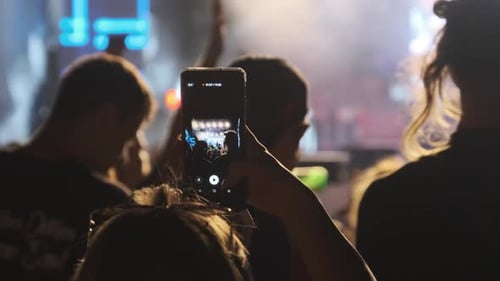 Frau Hand mit Smartphone macht Video beim Live-Rock-Konzert. Zeitlupe