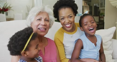 Happy Family Members Smiling on White Sofa