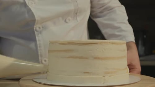 Chef Decorating Cake With White Frosting
