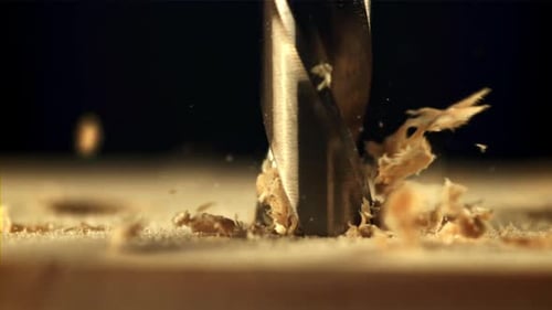 Drill Bit Drilling Into Wood With Flying Shavings