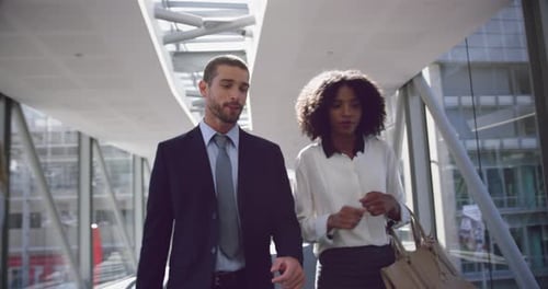 Business people interacting with each other in the corridor at office 4k