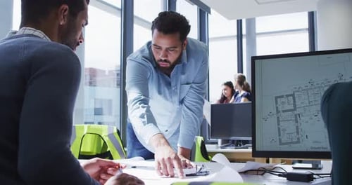 Architects Collaborating on Building Design in Office