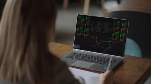 Asian Businesswoman Analyzing a Graphic of a Stock Exchange Chart