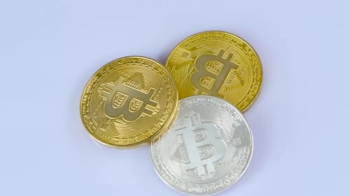 Shiny Bitcoin Coins Rotating on White Surface