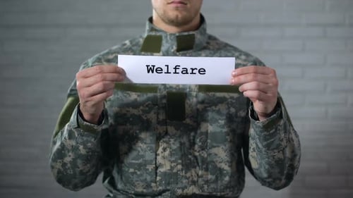 Welfare Word Written on Sign in Hands of Male Soldier, Financial Aid, Support