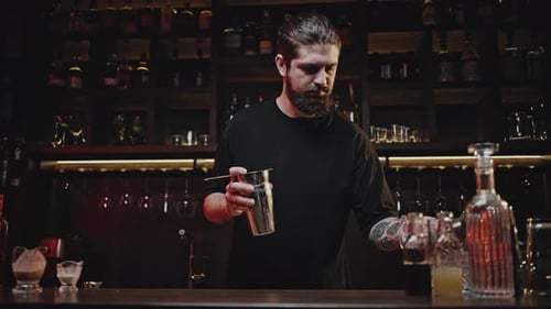 Bartender Preparing a Cocktail at a Dark Bar