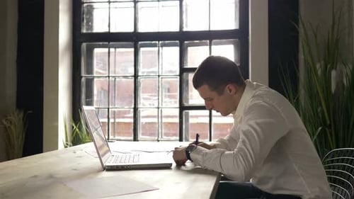 businessman working with a laptop in the office by the window