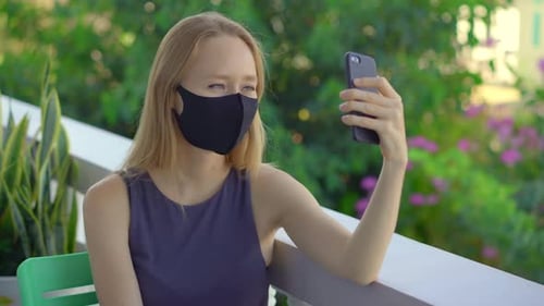 Woman Wearing Mask Using Phone Outdoors