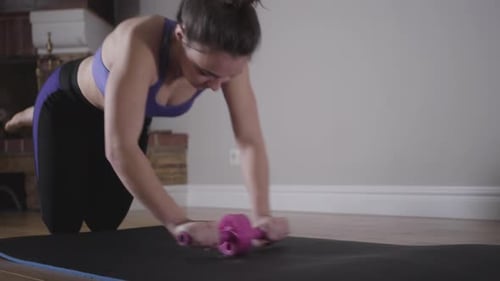 Beautiful Slim Woman Training with Rolling Wheel. Workout of Young Caucasian Brunette Girl in Sport