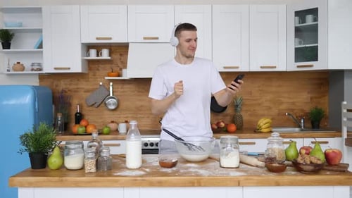 Man Dancing and Listening to Music in Kitchen