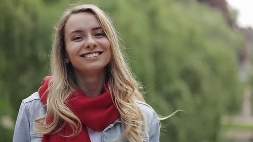 Portrait of Young Beautiful Woman Wearing in Red Scarf Standing Outside City Park. Gorgeous Woman