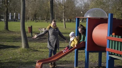 Family playing at slide in public playground, Zagreb, Croatia.