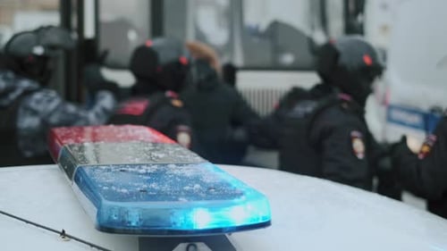 Des policiers vérifient les fugitifs avant de les emballer dans un paddy wagon