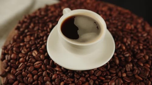 Close Up Coffee Cup on Roasted Coffee Beans