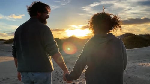 Romantic Couple Holding Hands on Beach at Sunset