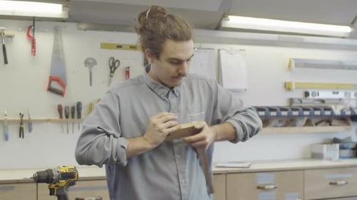 Young Carpenter Joining Together Furniture Components at Workshop