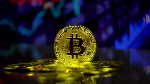 Haufen Bitcoins mit beweglichem Börsendiagramm-Hintergrund.