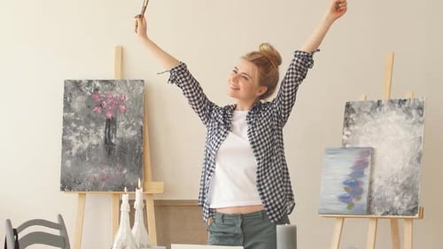 Happy Young Artist with Paintbrushes in Studio