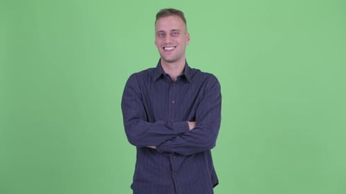 Smiling Man With Arms Crossed on Green Background