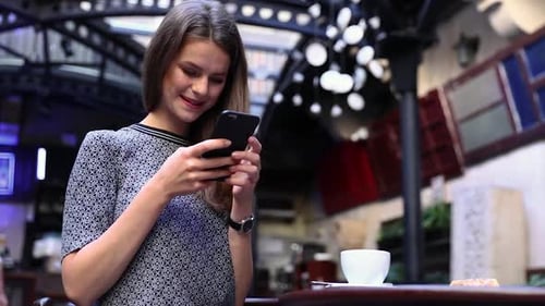 Woman With Phone At Cafe Drinking Coffee