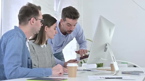 Team Collaborating on Computer in Modern Office