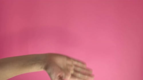 Arm and Hand Making Gestures on Pink Background