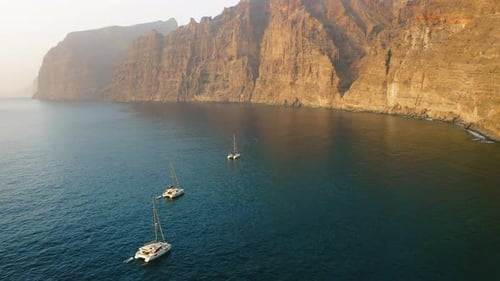 Aerial View of White Sailboats Float on Serene Seascape Open Ocean Cliff