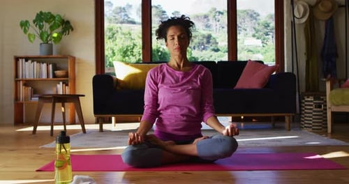 Woman Meditates in Lotus Position at Home