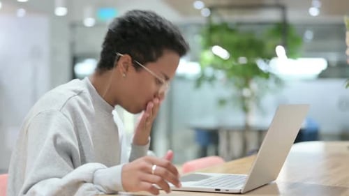 Young Adult Coughs While Working on Laptop