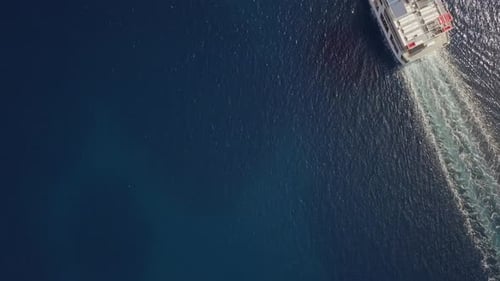 Aerial view above ferry boat with cars driving in the mediterranean sea, Greece.