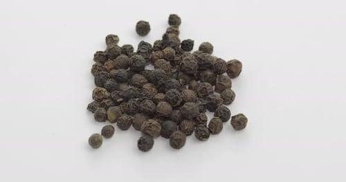 Pile of Black Peppercorns on White Background