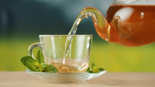 Pouring Hot Tea in Cup Closeup