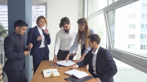 Director of the Company Holds a Meeting with His Subordinates. Managers View the Documents in Office