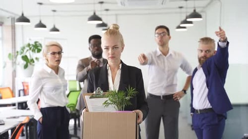 Une stagiaire caucasienne tenant une boîte en carton avec ses effets personnels termine son travail dans l'entreprise