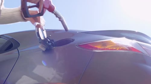 Male Hands Putting Nozzle into Car Tank