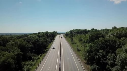 Aerial Shot of a Highway Passing Through the Rural Countryside and Green Forest