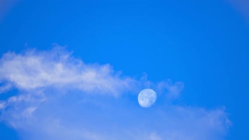 Moon and Cloudscape Moving in a Blue Sky