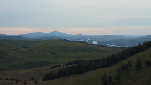 Aerial view from a drone on valley and mountains under blue sky with clouds
