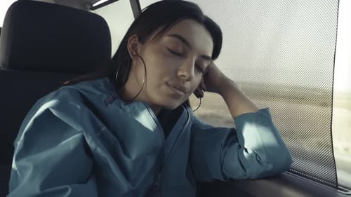 Young Woman Sleeping in Car on Road Trip