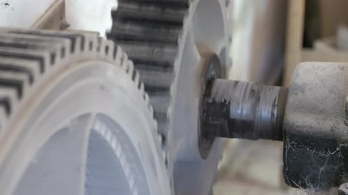 Close up shot of industrial gears of machinery rotating in factory
