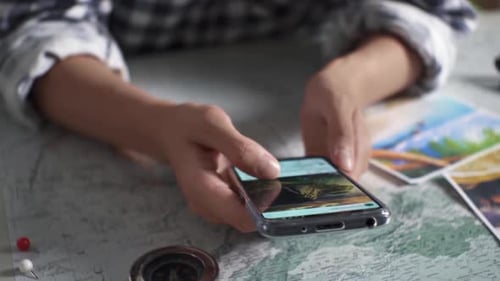 Hands Scroll Through Phone Planning Vacation