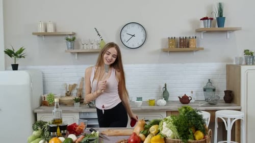 Energetic Woman Dancing While Cooking in Kitchen
