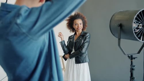 Woman in Dress and Leather Jacket Poses