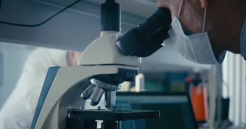 Scientist Using Microscope in Bright Research Laboratory
