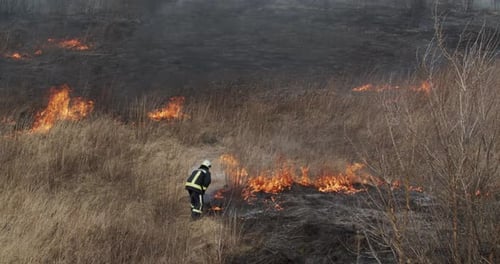 Firefighter Shovels Extinguish Fire In The Field